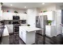 Kitchen featuring white cabinets, stainless steel appliances, a center island and dark wood-style floors at 10447 Pintail Ln, Indianapolis, IN 46239