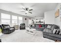 Spacious living room featuring neutral carpet, ample seating, ceiling fan, and natural light at 10447 Pintail Ln, Indianapolis, IN 46239