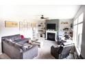 Cozy living room with a modern fireplace, comfortable seating, stylish decor and a ceiling fan at 10447 Pintail Ln, Indianapolis, IN 46239