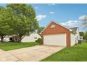 Home featuring a two-car garage, manicured landscaping, and a long driveway at 1093 Country Meadow Ct, Franklin, IN 46131