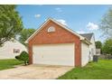 Home featuring a two-car garage with brick accents and manicured landscaping at 1093 Country Meadow Ct, Franklin, IN 46131