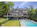 Elegant multi-level lake house showcasing a spacious deck and inviting pool area for outdoor relaxation at 11715 Landings Dr, Indianapolis, IN 46256