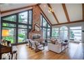 Bright living room featuring a soaring brick fireplace, hardwood floors, and expansive windows with lake views at 11715 Landings Dr, Indianapolis, IN 46256