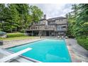 Luxury home featuring a large inground pool, stone patio, and beautiful backyard, perfect for outdoor enjoyment at 11715 Landings Dr, Indianapolis, IN 46256