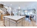Bright and modern kitchen showcasing a large island, stainless steel appliances, and hardwood floors throughout the living space at 13217 E 131St St, Fishers, IN 46037