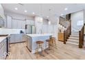 Well-lit kitchen with a large island, stainless steel appliances, and hardwood floors with staircase to the second floor at 13217 E 131St St, Fishers, IN 46037