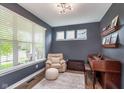 A well-lit space with a comfortable chair, piano and ample natural light streaming through a large window at 14075 Knightstown E Dr, Carmel, IN 46033