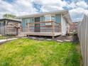 Inviting light blue home with charming front porch and landscaped yard with stone steps leading to the fenced side yard at 1415 Lawton Ave, Indianapolis, IN 46203