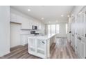 Bright kitchen features white cabinets, stainless steel appliances, a center island, and hardwood floors at 14515 Hanford Ln, Carmel, IN 46074