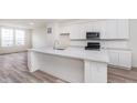 Spacious kitchen features a center island, white cabinets, stainless steel appliances and hardwood floors at 14515 Hanford Ln, Carmel, IN 46074