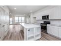 Light-filled kitchen with island, stainless steel appliances, white cabinetry, and access to the living room at 14515 Hanford Ln, Carmel, IN 46074