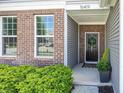 Close-up of front door with brick and vinyl siding, a wreath, and a welcoming entrance at 16419 Connolly Dr, Westfield, IN 46074