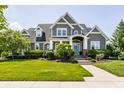 Beautiful gray two-story home with lush green lawn and manicured landscaping at 1799 Hourglass Dr, Carmel, IN 46032