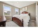 Cozy bedroom featuring a classic wooden bed frame, soft carpeting, and lots of natural light at 1807 Orchard Dr, Fortville, IN 46040
