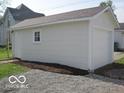 White garage with a side entry door and an overhead garage door at 201 W Essex St, Lebanon, IN 46052