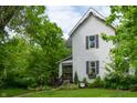 Charming home with a landscaped front yard and inviting porch with decorative details at 232 S Audubon Rd, Indianapolis, IN 46219