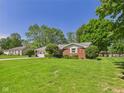Lovely brick ranch home featuring a spacious front lawn and lush greenery at 25 N Mustin Dr, Anderson, IN 46012