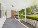 Inviting covered front porch featuring brick accents and classic white columns at 25 N Mustin Dr, Anderson, IN 46012