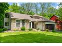 Beautiful exterior view of the home showcasing stone, siding, and landscaped front yard at 3230 Amherst St, Indianapolis, IN 46268