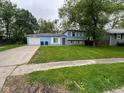 Charming blue two-story home with a driveway and a well-maintained front lawn at 3628 Breen Dr, Indianapolis, IN 46235