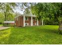 Inviting brick home with a lush green lawn and covered front porch at 502 S Harrison St, Alexandria, IN 46001
