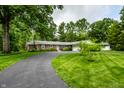 Charming brick home with a winding driveway and beautiful landscaping creates an inviting entrance at 5415 Kilmer Ln, Indianapolis, IN 46250