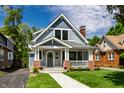 Charming two-story home with a well-manicured lawn and inviting front porch at 5682 Broadway St, Indianapolis, IN 46220