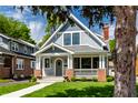 Charming two-story home with a well-manicured lawn and inviting front porch at 5682 Broadway St, Indianapolis, IN 46220