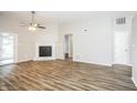 Spacious living room featuring modern flooring, a white fireplace and a ceiling fan at 6121 Jester Ct, Indianapolis, IN 46254