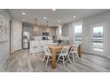 Open-concept kitchen and dining area with stainless steel appliances, grey cabinetry, and natural light at 6868 Jacone Dr, Brownsburg, IN 46112