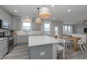 Beautiful, open kitchen with a large island, stainless steel appliances, and view into the dining room at 6868 Jacone Dr, Brownsburg, IN 46112