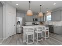Stylish kitchen featuring a large island with seating, stainless steel appliances, and grey cabinets at 6868 Jacone Dr, Brownsburg, IN 46112