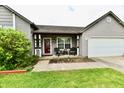 Inviting porch with chairs and a table, complemented by a wreath on the front door at 73 Suncrest Dr, Greenwood, IN 46143