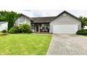 Well-maintained gray home featuring an attached garage, driveway and lush front yard at 73 Suncrest Dr, Greenwood, IN 46143