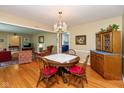 Bright dining room featuring a chandelier, hardwood floors, and access to the kitchen at 7401 Spring Mill Rd, Indianapolis, IN 46260