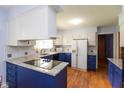 Well-lit kitchen with blue and white cabinets, modern appliances, and granite countertops at 7401 Spring Mill Rd, Indianapolis, IN 46260