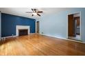 Spacious living room boasting hardwood floors and a traditional fireplace with decorative mantle at 7910 N College Ave, Indianapolis, IN 46240
