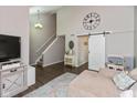 Open living room with vaulted ceiling, statement clock, barn door, and neutral décor at 8958 Wooster Ct, Fishers, IN 46038