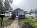 Charming home with a dark green exterior and a sunny, glass enclosed, front porch at 946 N Somerset Ave, Indianapolis, IN 46222
