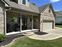 Charming front porch with rocking chairs, brick detailing, and hanging plants, perfect for relaxing outdoors at 10 Sara Ct, Whiteland, IN 46184