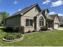 Beautifully landscaped front yard with brick accents, green grass, and a charming brick and siding home at 10 Sara Ct, Whiteland, IN 46184