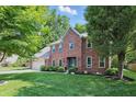 Attractive two-story brick home with a lush green lawn and mature trees in a quiet neighborhood at 10418 Forest Creek Dr, Indianapolis, IN 46239