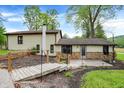 Backyard view with stone landscape wall and wooden foot bridge to the home's back entrance at 10972 W Old Nashville Rd, Columbus, IN 47201