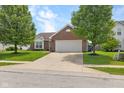 Charming single Gathering home with two car garage, brick facade, and front yard with mature landscaping at 11209 Black Gold Dr, Noblesville, IN 46060