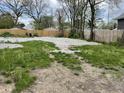 Large gravel backyard featuring a new wooden fence and scattered greenery with mature trees in a residential neighborhood at 1164 Groff Ave, Indianapolis, IN 46222
