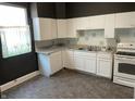 Traditional kitchen features white cabinets, appliances, and worn vinyl flooring at 1164 Groff Ave, Indianapolis, IN 46222