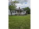 A cozy single-story home with a modest front porch surrounded by a green lawn at 1168 N Gladstone Ave, Indianapolis, IN 46201