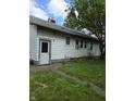 Shows the side of a small white house with a side door and windows at 1168 N Gladstone Ave, Indianapolis, IN 46201