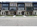 Row of new townhomes with mixed brick and stone exteriors, black window frames, and manicured landscaping at 120 First Ne Ave, Carmel, IN 46032