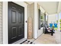 Inviting covered front porch with black door, modern welcome sign, and comfortable seating for enjoying the outdoors at 12993 E 131St St, Fishers, IN 46037